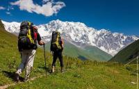 двое туристов идут по маршруту в горах